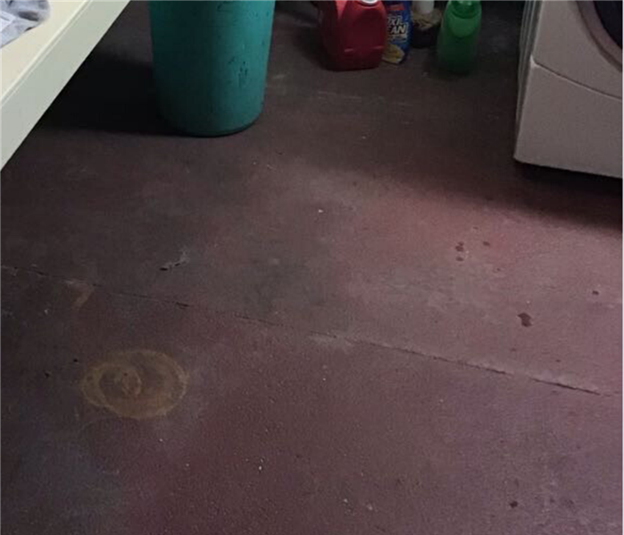 A cement flooring of a laundry room.