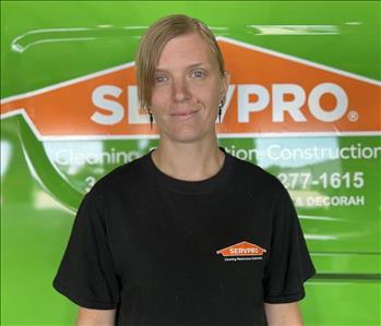 Blonde Servpro employee in front of green truck