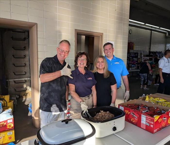 Employees behind food table