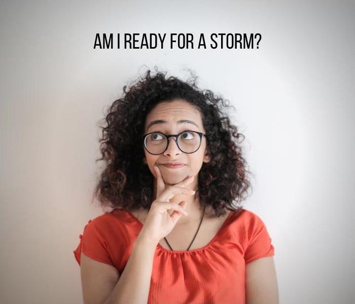 A tan woman with curly hair and glasses looks up in a pensive manner? Text that reads “Am I ready for a storm?” is on the top